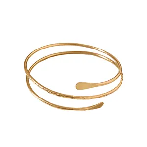 Elegant gold spiral open bangle featuring hammered texture on a clean white background