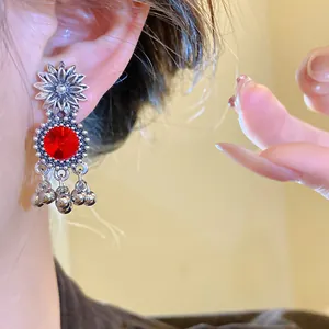 Detailed view of vintage royal style sunflower earrings featuring red crystals on an ear