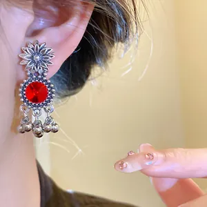 Detailed view of a vintage court style earring with a red crystal sunflower design