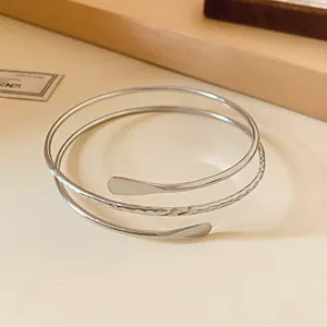 Close-up of a silver multi-layer open bracelet with a hammered texture finish.