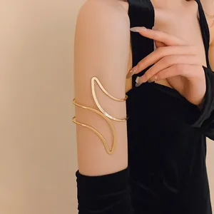 Close-up of a stylish minimalist gold leaf-shaped open arm cuff jewelry on a model arm.