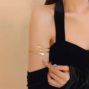 Close-up view of an elegant gold multi-layered wrap arm cuff worn on the upper arm