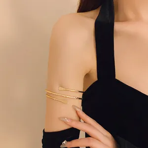 Close-up of minimalist gold wrap arm cuff bracelet on woman's upper arm