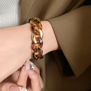 Close-up detail of a vintage chunky chain bracelet with gold and amber resin links