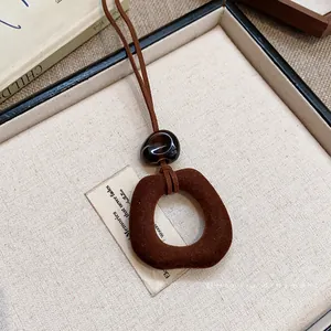 Collana con ciondolo geometrico marrone con perla in resina su catena lunga autunnale