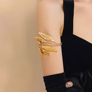 Elegant gold leaf arm cuff shown on upper arm with minimalist design for luxury fashion