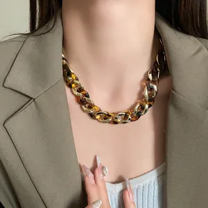 Close-up detail shot of a chunky geometric leopard print chain necklace worn by a model