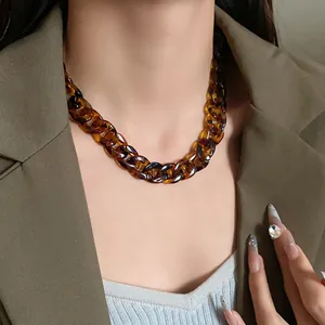 Close-up detail of a vintage leopard print resin chain necklace worn with a blazer
