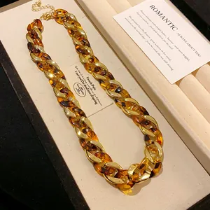 Macro detailed view of the chunky amber leopard resin and gold metal chain links
