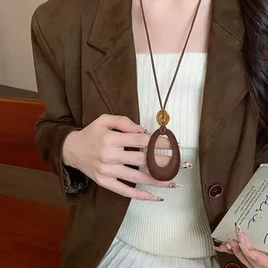 Primo piano di una collana con ciondolo geometrico in resina marrone per l'autunno