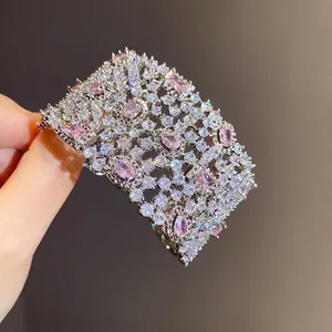 Bracciale rigido geometrico traforato con scintillanti zirconi rosa di lusso.