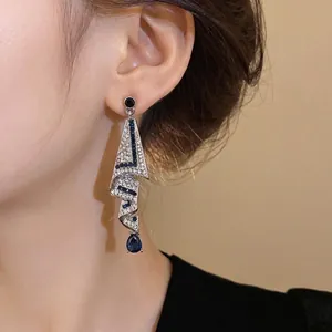 Elegant silver needle drop earrings with sparkling crystals and navy blue accents.