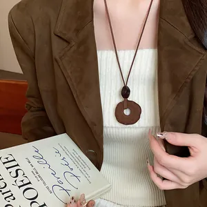 Collana con ciondolo geometrico in resina floccata marrone per la moda autunnale.