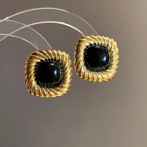 Orecchini a perno quadrati vintage con pietra nera e finitura in oro a trama intrecciata.