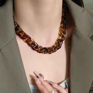 Close-up view of a vintage leopard print acrylic chunky chain necklace on a female model