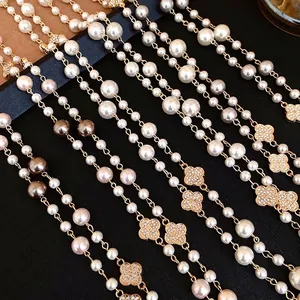 Elegante collana di perle lunga a più strati con ciondoli a quadrifoglio dorati con strass
