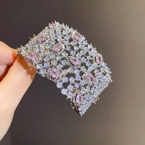Dettaglio di bracciale rigido geometrico traforato con pietre di zirconia bianche e rosa