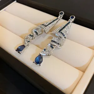 Detailed macro view of elegant silver teardrop earrings with blue and white crystals