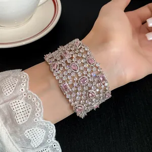 Dettaglio di un bracciale rigido geometrico scavato in zircone scintillante sul polso.