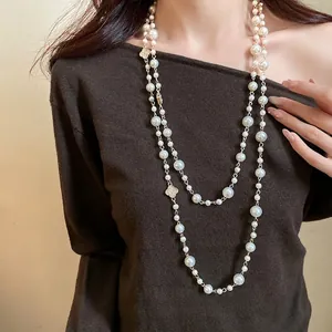 Elegante collana lunga a due strati di perle con motivi a fiori in strass.