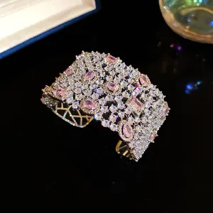 Primo piano di un bracciale rigido largo traforato con zirconi rosa e bianchi brillanti