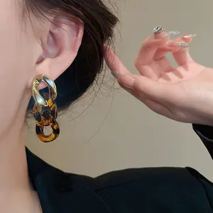 Close-up view of retro leopard print chain link earrings with polished gold-tone accent