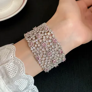 Dettaglio di un lussuoso bracciale traforato con scintillanti zirconi rosa e trasparenti