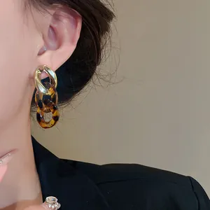 Close-up view of elegant retro tortoiseshell acrylic chain earrings with gold metallic links.