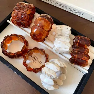 Detailed view of marbled and tortoiseshell elastic bracelets in a jewelry tray