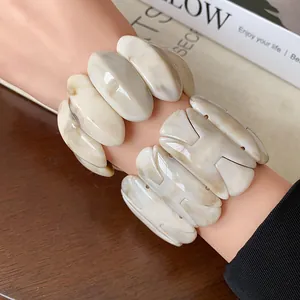 Close-up detail of vintage marbled resin H-shaped and oval elastic chunky stretch bracelets