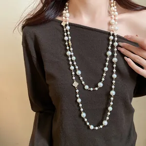 Dettaglio di una lunga collana di perle a strati con motivi floreali scintillanti