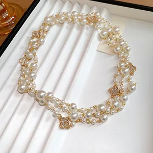 Dettaglio di una collana di perle a più fili con ciondoli a fiore di diamanti stile vintage
