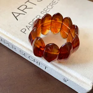 Detailed close-up view of vintage amber marbled oval elastic bracelet resting on a book