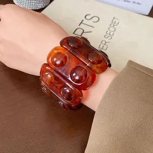 Detailed view of a vintage amber resin elastic bracelet with textured oval design
