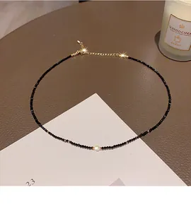 Detailed view of minimalist black crystal beaded choker necklace with gold extension chain.