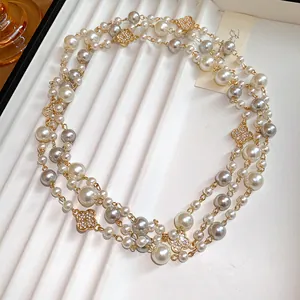 Dettaglio squisito di elegante collana di perle a più fili con ciondoli a quadrifoglio.