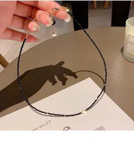 Detailed shot of a minimalist black crystal beaded necklace with gold accents and clasp