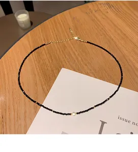 Detailed view of minimalist black beaded necklace with a centerpiece sparkling gem