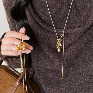 Dettaglio della collana lunga Maillard vintage con fiori in resina e perle per maglioni autunnali