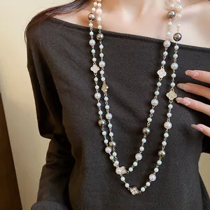 Vista dettagliata della collana lunga di perle con motivi floreali brillanti su maglia