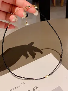 Detailed view of a minimalist black crystal beaded choker with gold spacer accents.
