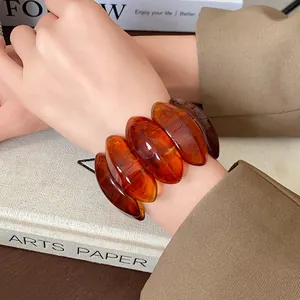 Detailed view of amber smudged resin oval beads on an elastic stretch bracelet