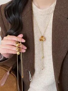 Collana vintage stile Maillard con fiori di resina marrone e perle indossata da una modella