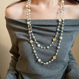 Dettaglio di una lunga collana di perle a doppio strato con fiori di cristallo lusso