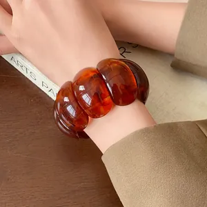 Close-up detail of a vintage amber resin elastic bracelet with chunky oval smudged beads