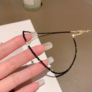 Elegante collana di cristallo nero sfaccettato con perla e distanziatori dorati.