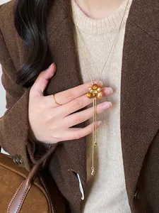 Dettaglio di una collana vintage stile Maillard con pendente a fiore in resina e perle
