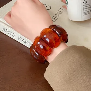 Detailed view of the marbled texture on a retro amber chunky elastic resin bracelet.