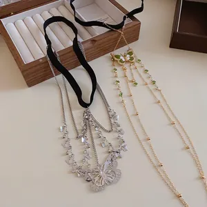 Detail view of butterfly tassel thigh chains in elegant silver and gold finishes.
