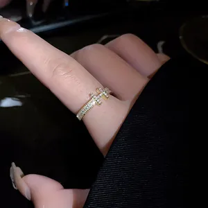 Close-up of gold-plated open ring with zircon insets in unique letter design